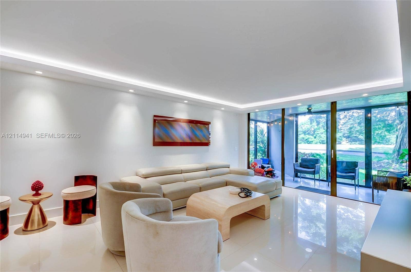 16175 Golf Club Road, #113, Weston, FL 33326 Living space featuring light-toned flooring, recessed ceiling lighting with perimeter cove illumination, and floor-to-ceiling glass panel sliding doors