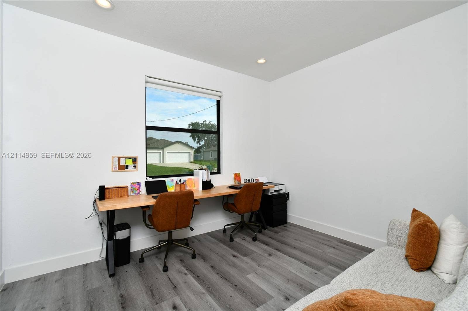 8017 Sunrise Circle, Labelle, FL 33935 Neutral-toned interior space featuring wood-finish flooring, recessed lighting, and a window with a black frame