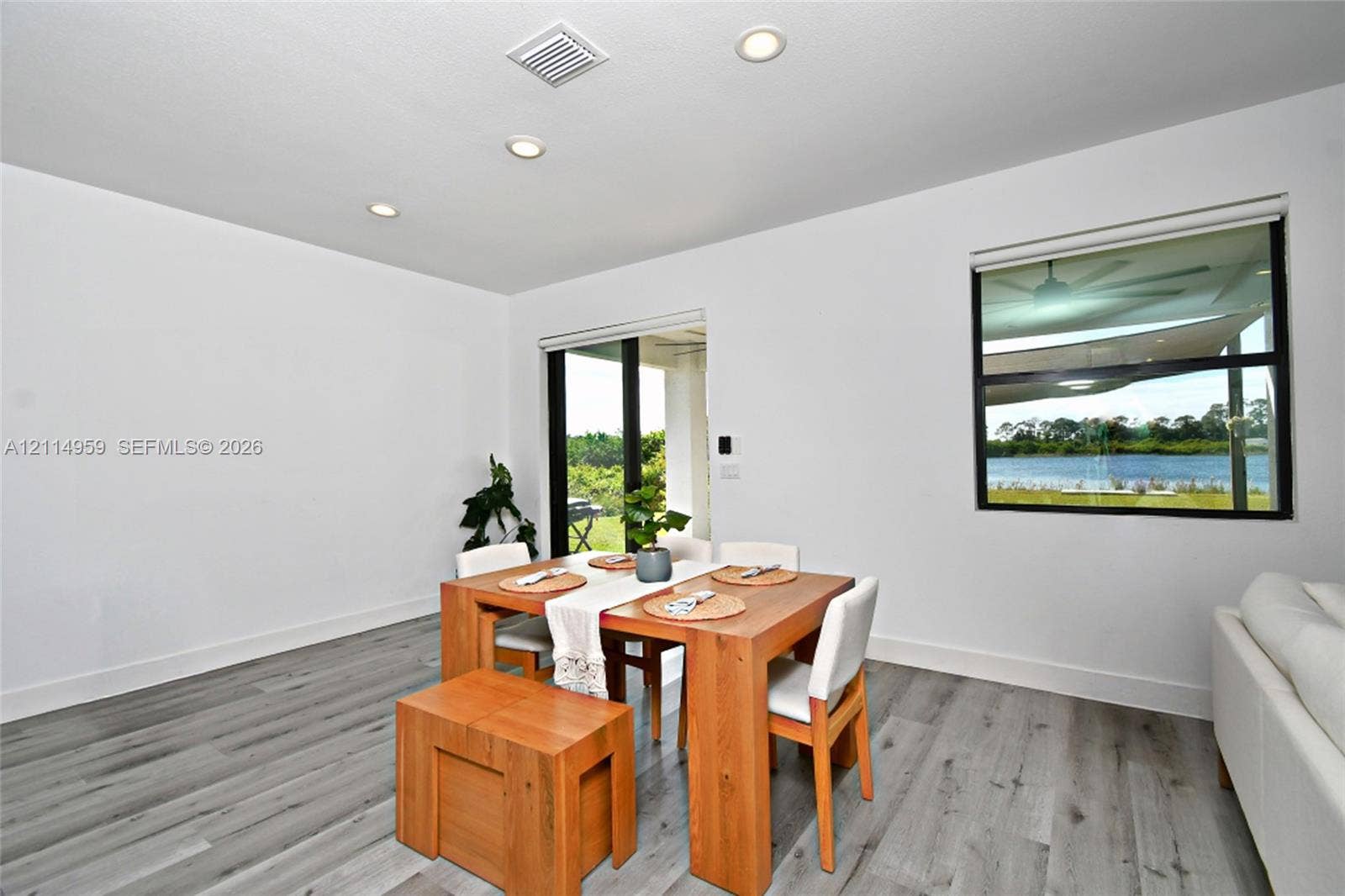 8017 Sunrise Circle, Labelle, FL 33935 Wood-finish flooring, recessed lighting, sliding glass door, and picture window featuring water scenery