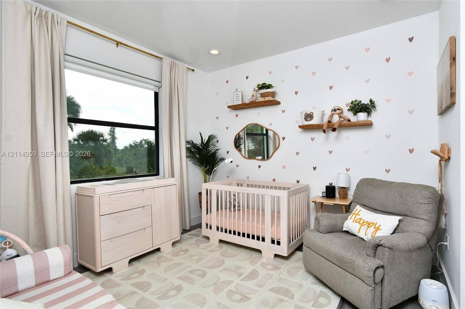 8017 Sunrise Circle, Labelle, FL 33935 Bedroom featuring two natural wood floating shelves, an organic-shaped wall mirror, a large window, and recessed ceiling lighting
