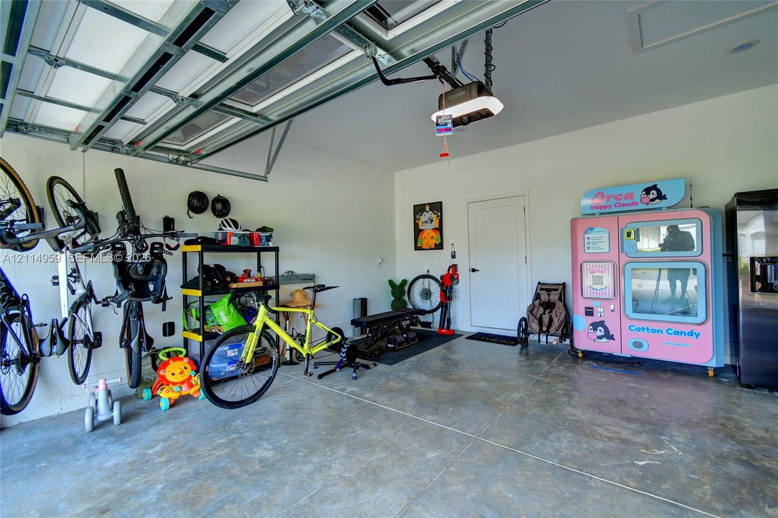 8017 Sunrise Circle, Labelle, FL 33935 Attached two-car garage featuring a concrete floor, finished white walls, and a motorized overhead door opener