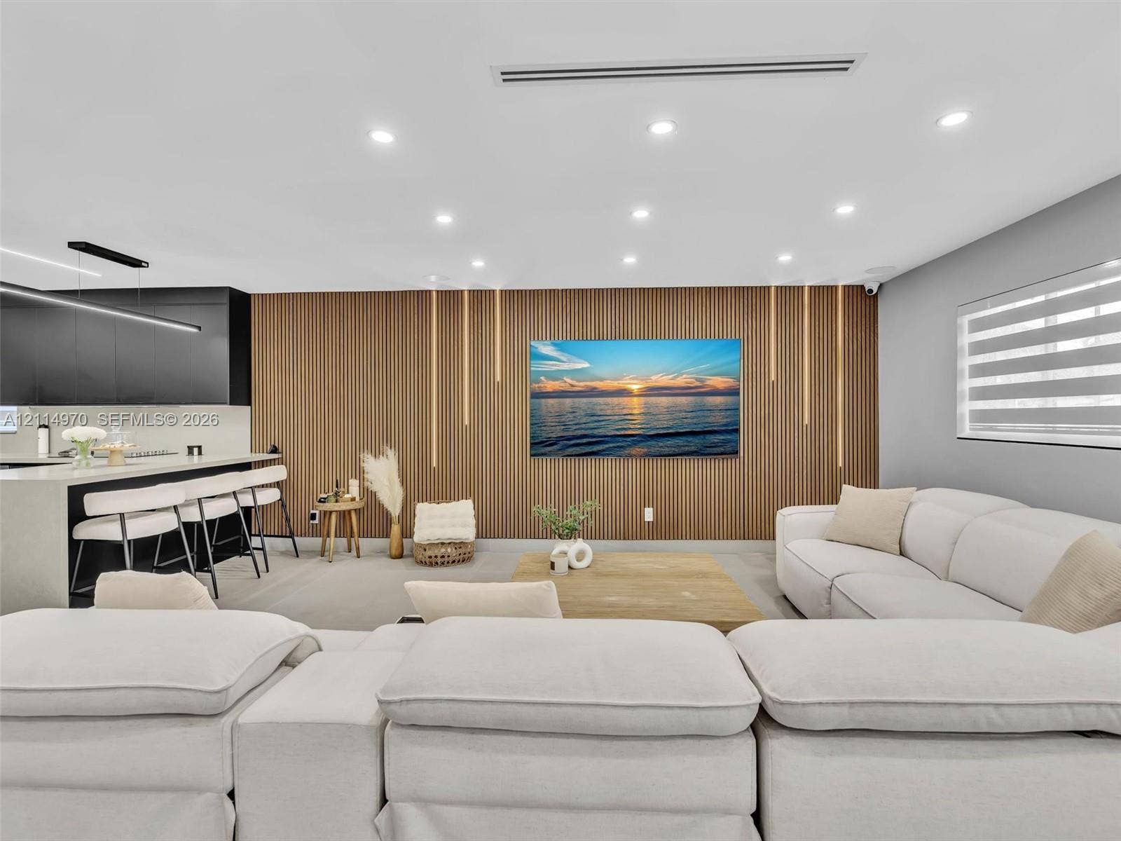 4204 Van Buren Street, Hollywood, Hollywood, FL 33021 Slatted wood accent wall with integrated linear lighting, recessed ceiling lighting, kitchen island with stone-surface countertop, and matte black cabinetry
