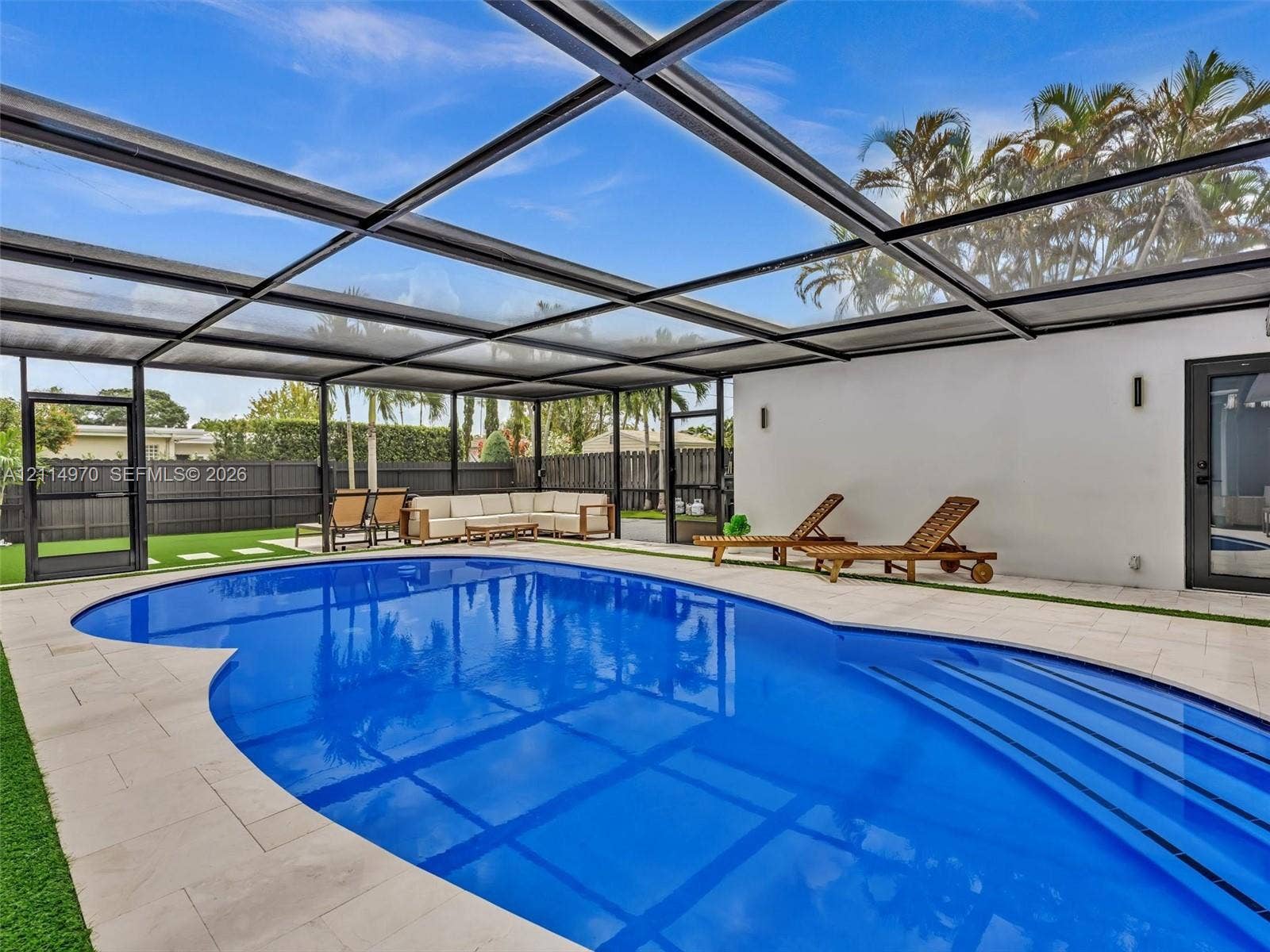 4204 Van Buren Street, Hollywood, Hollywood, FL 33021 Screened-in patio featuring a swimming pool with integrated stairs, light-toned stone tile decking, and a privacy fence