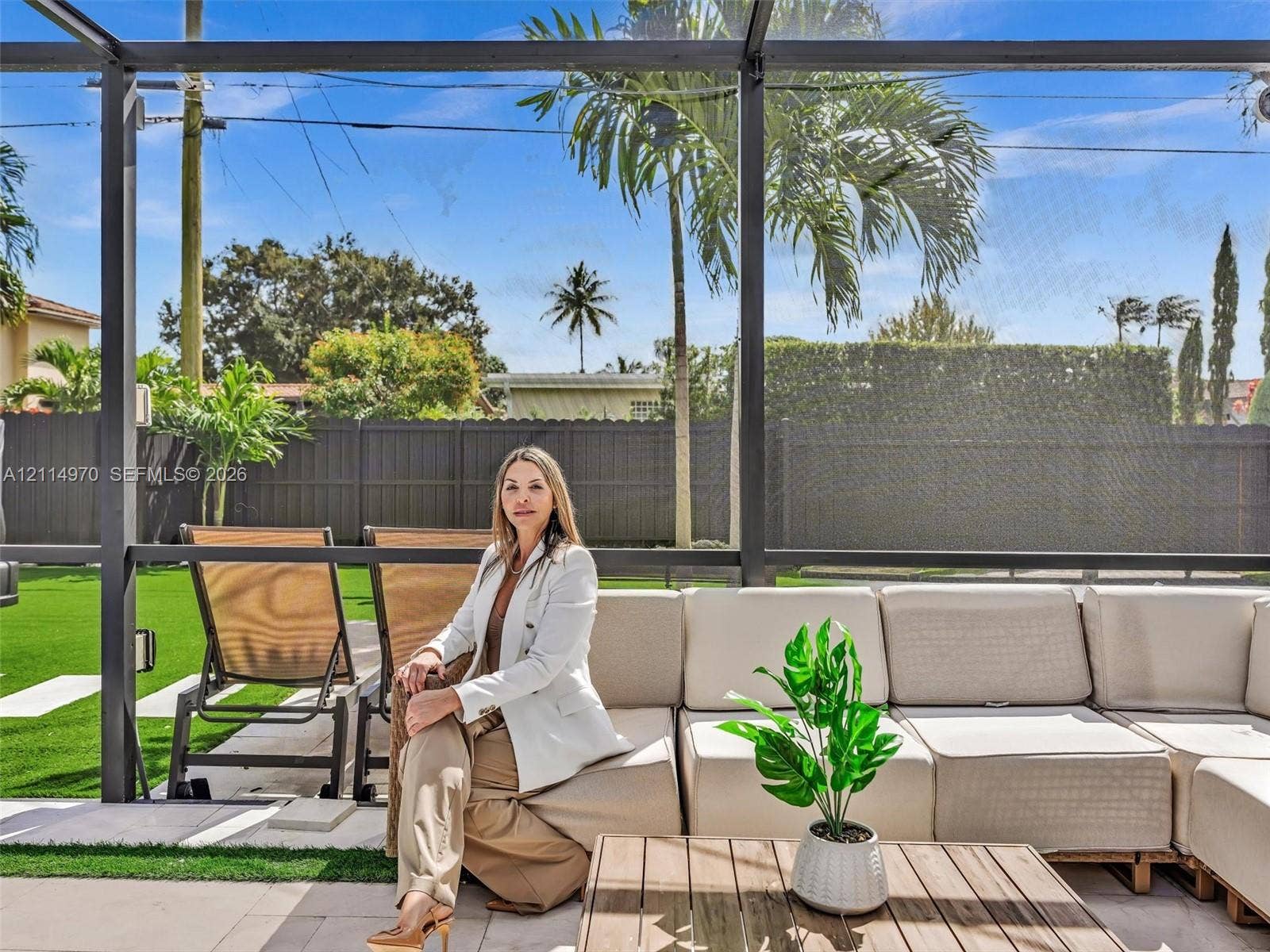 4204 Van Buren Street, Hollywood, Hollywood, FL 33021 Screened-in outdoor living area featuring paved patio flooring, synthetic turf lawn, and solid perimeter fencing