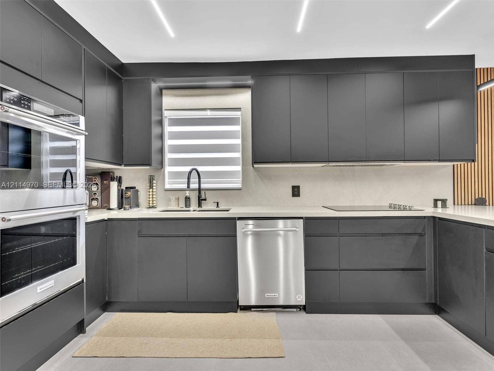 4204 Van Buren Street, Hollywood, Hollywood, FL 33021 Contemporary kitchen featuring matte charcoal cabinetry, stainless steel double wall ovens and dishwasher, solid-surface countertops, and recessed linear ceiling lighting