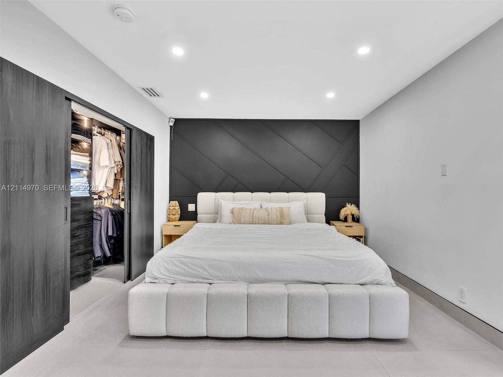 4204 Van Buren Street, Hollywood, Hollywood, FL 33021 Accent wall with geometric trim detail, sliding dark-finish wardrobe doors, integrated recessed lighting, and large-format tile flooring