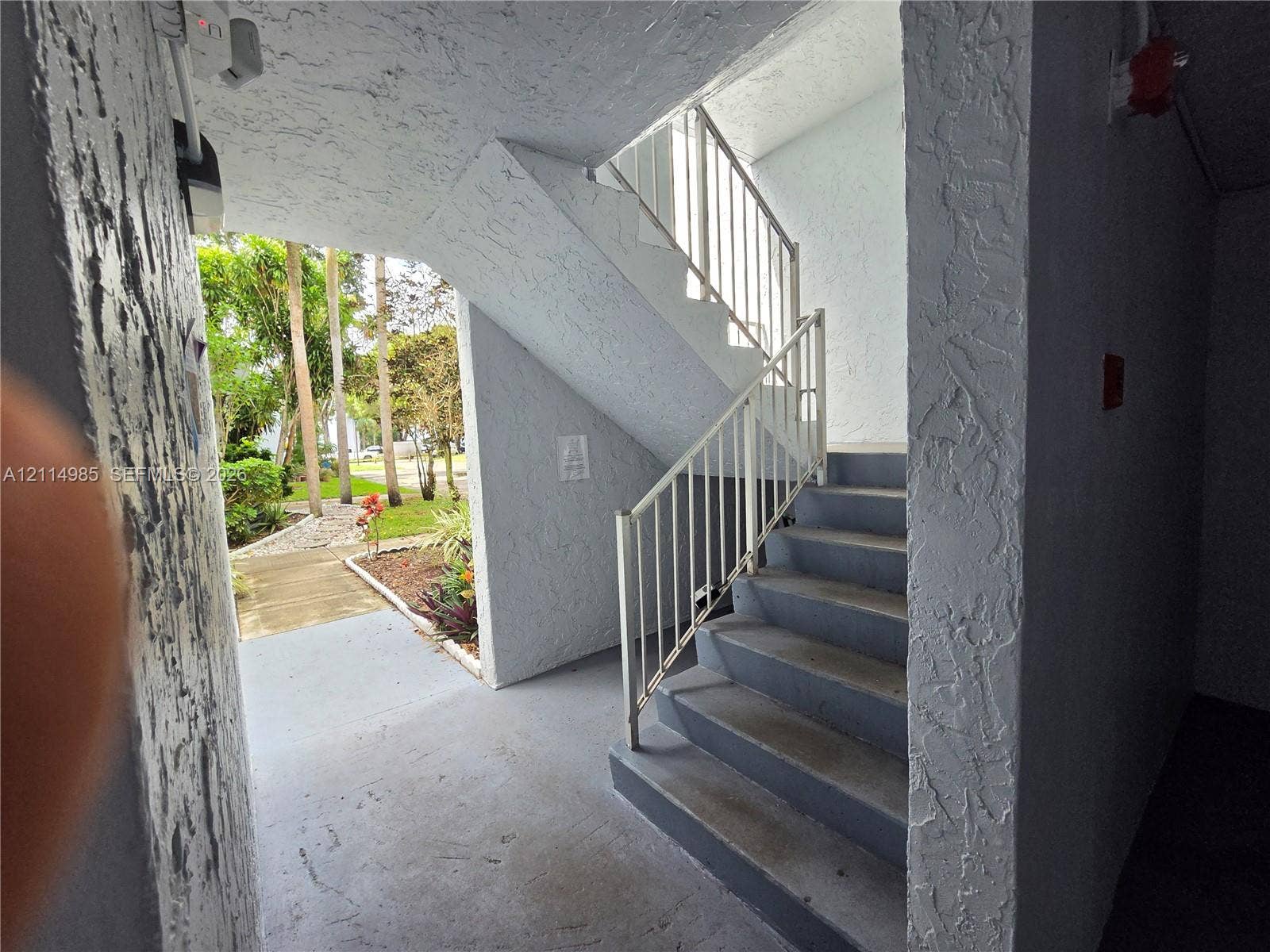 9441 Live Oak Place, #308, Davie, Davie, FL 33324 Exterior staircase with metal railings, concrete steps, and textured stucco walls