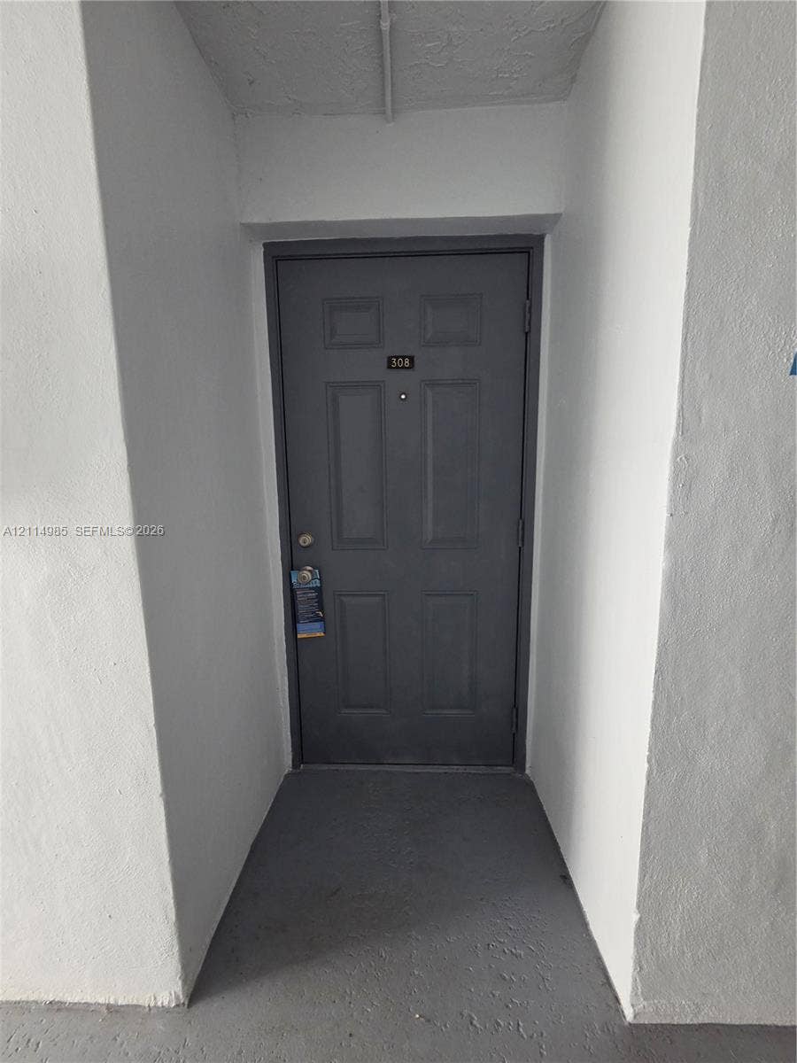 9441 Live Oak Place, #308, Davie, Davie, FL 33324 Six-panel entry door featuring a matte finish, a deadbolt lock, and a centered peephole