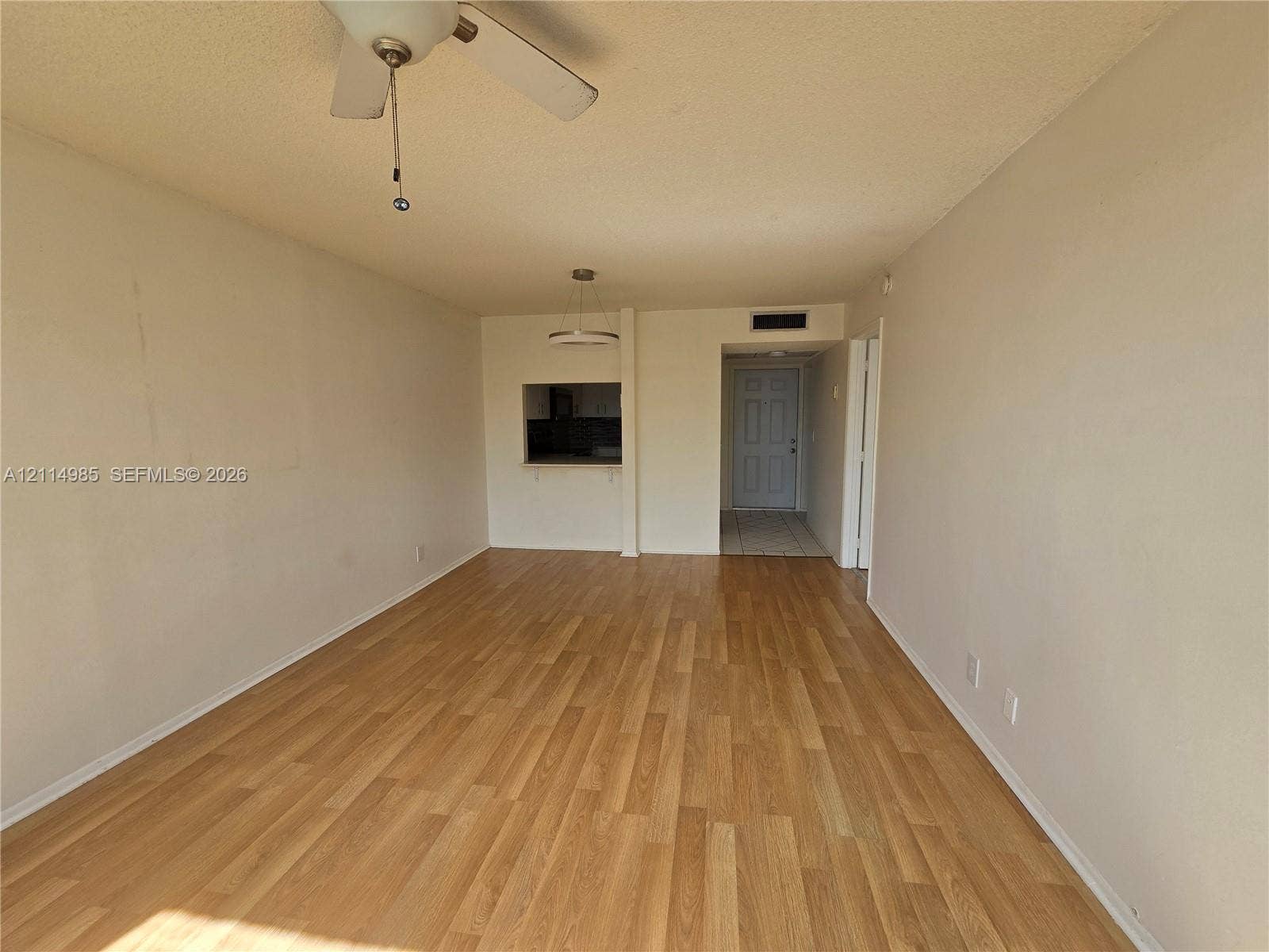 9441 Live Oak Place, #308, Davie, Davie, FL 33324 Open-concept room featuring wood-finish flooring, a ceiling fan, and a pass-through opening to the interior space