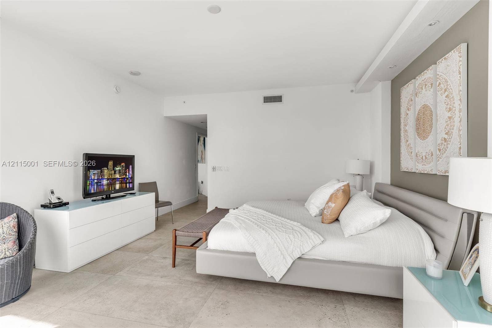 Large-format tile flooring, recessed ceiling lighting, and a neutral-toned accent wall