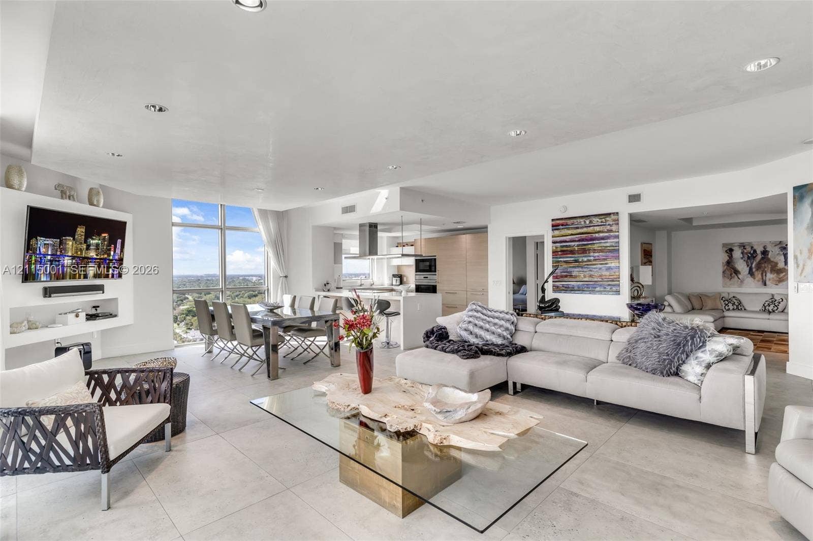 Open-concept interior featuring floor-to-ceiling windows, tile flooring, built-in recessed shelving, recessed lighting, and a modern kitchen island