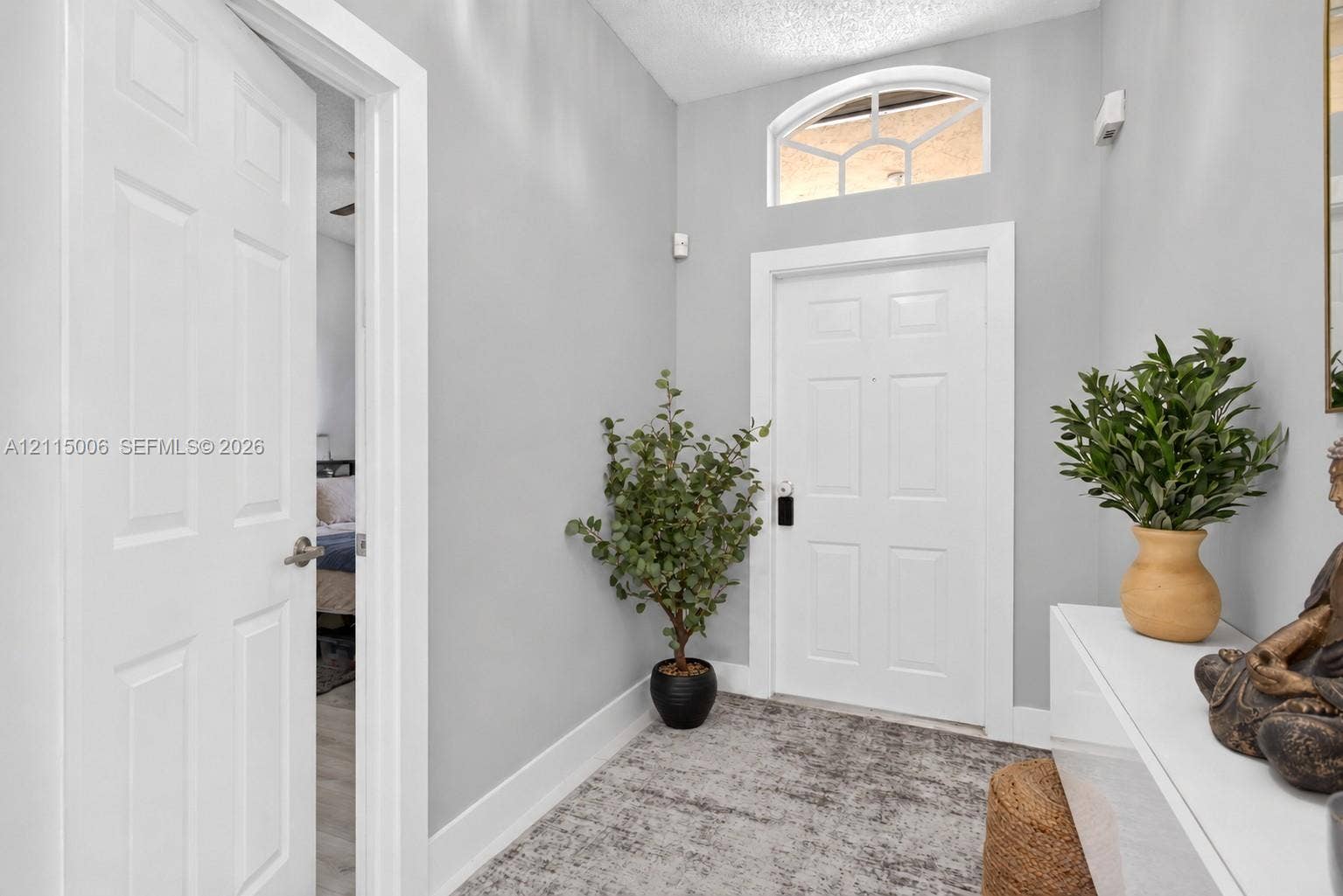 4812 NW 19th Street, Coconut Creek, FL 33063 Entryway featuring a white paneled door, arched transom window, and neutral wall color