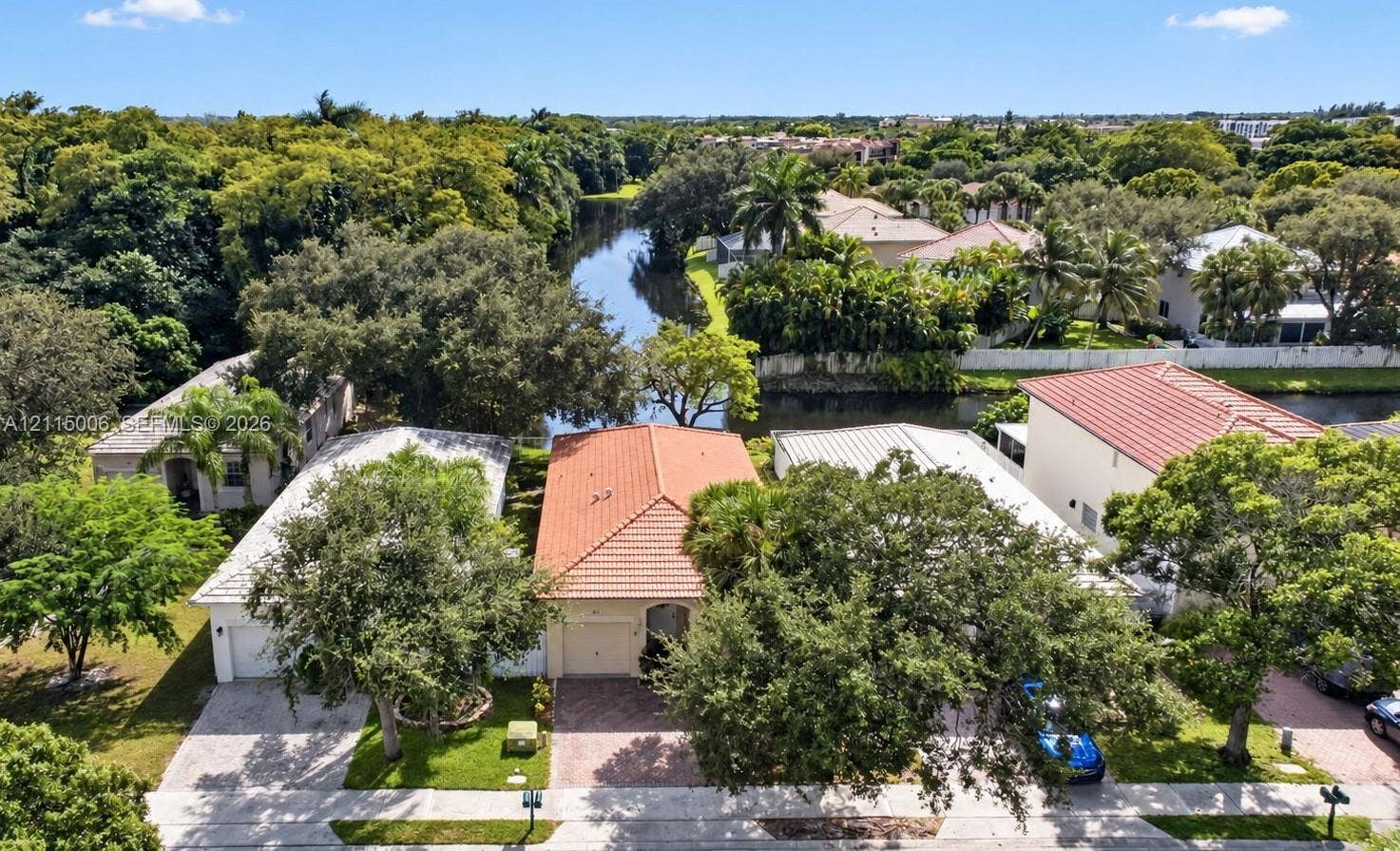 4812 NW 19th Street, Coconut Creek, FL 33063 Aerial perspective featuring residences with terracotta-style roof tiles, paved driveways, and mature landscaping situated along a waterway