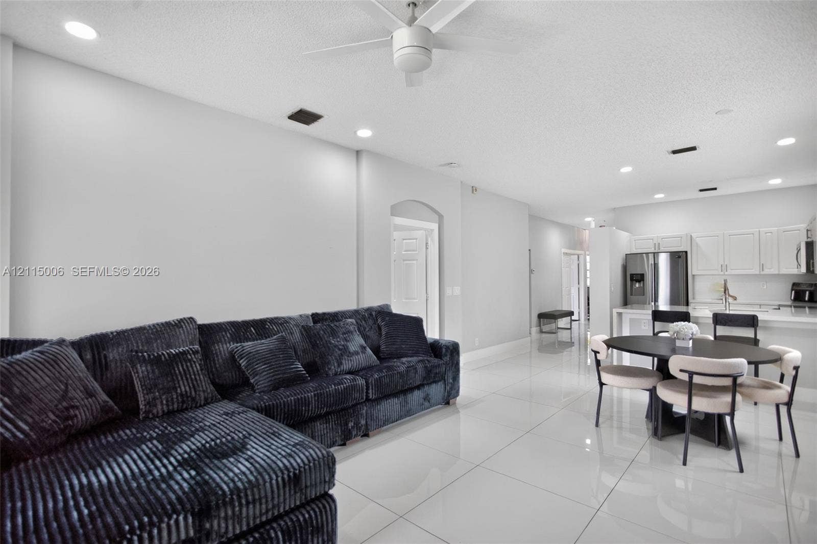 4812 NW 19th Street, Coconut Creek, FL 33063 Large-format tile flooring, recessed ceiling lighting, ceiling fan, and white kitchen cabinetry with stainless steel appliances