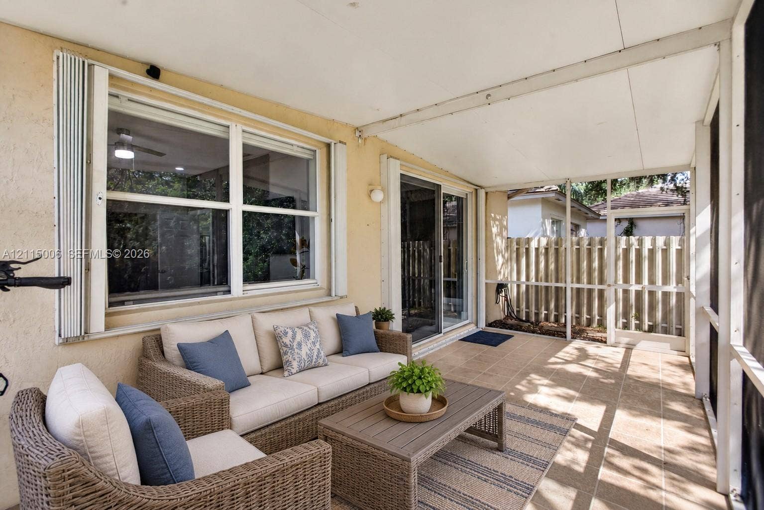 4812 NW 19th Street, Coconut Creek, FL 33063 Screened-in patio featuring tile flooring, metal framing, sliding glass doors, and a solid roof covering