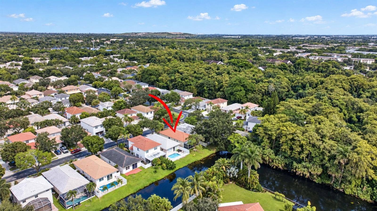 4812 NW 19th Street, Coconut Creek, FL 33063 Aerial perspective of a multi-story residence featuring a tile roof, an in-ground swimming pool, and a waterfront location