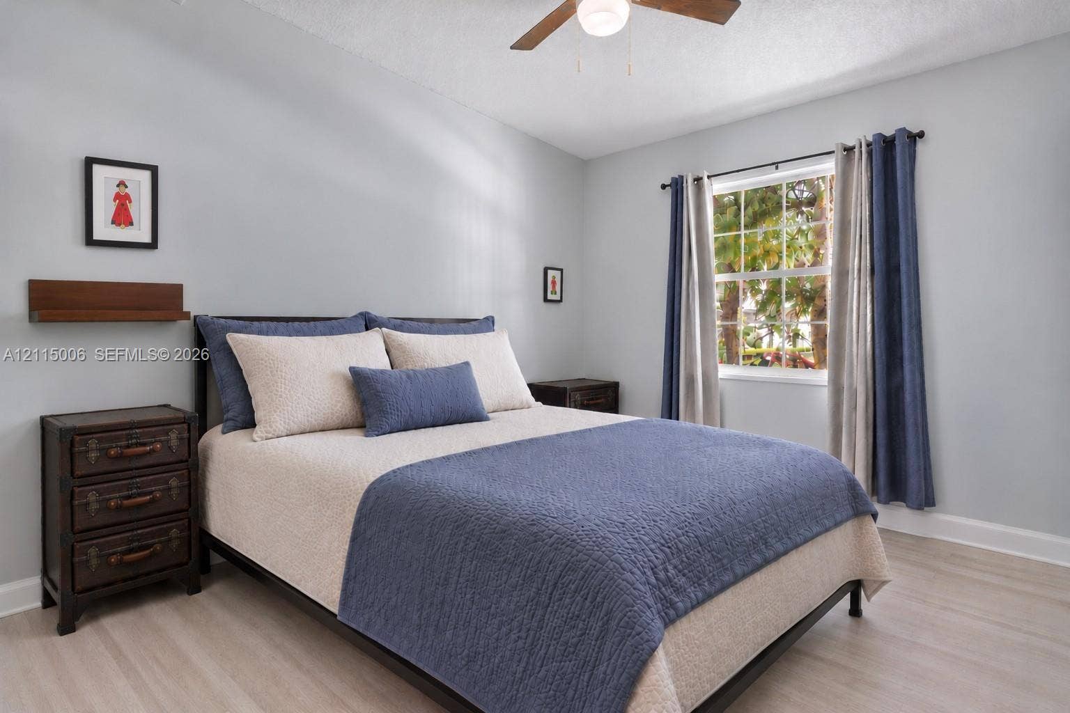4812 NW 19th Street, Coconut Creek, FL 33063 Neutral-toned interior featuring wood-finish flooring, a multi-pane window, and a ceiling fan with integrated lighting
