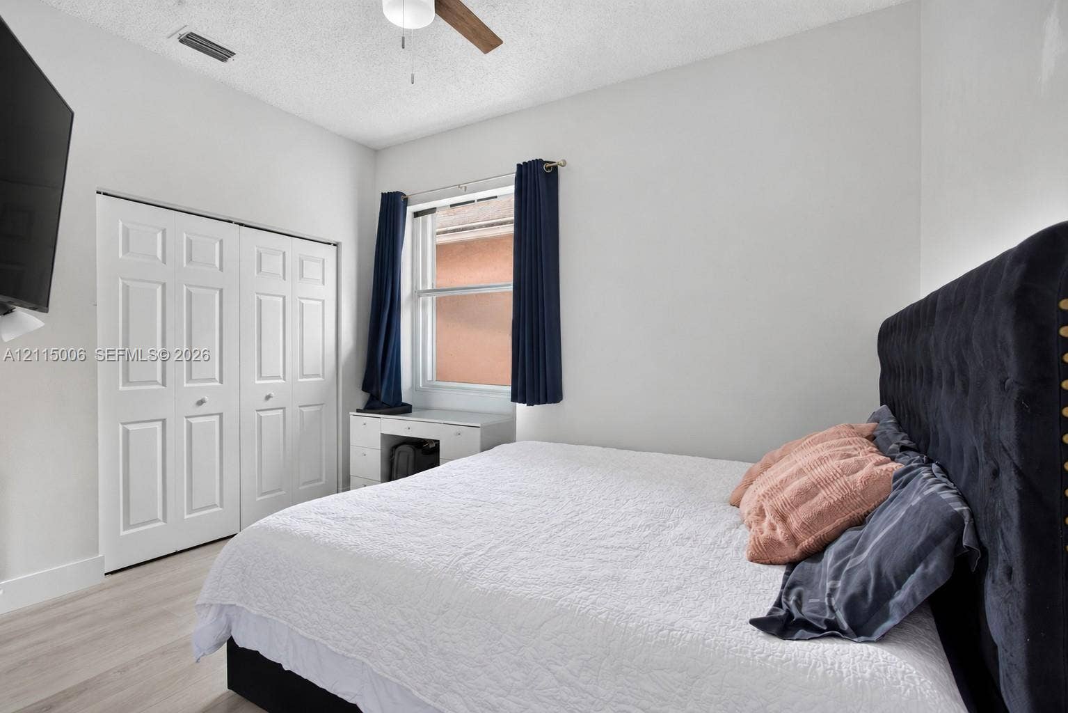 4812 NW 19th Street, Coconut Creek, FL 33063 Neutral-toned room featuring wood-finish flooring, a ceiling fan, and double-panel closet doors