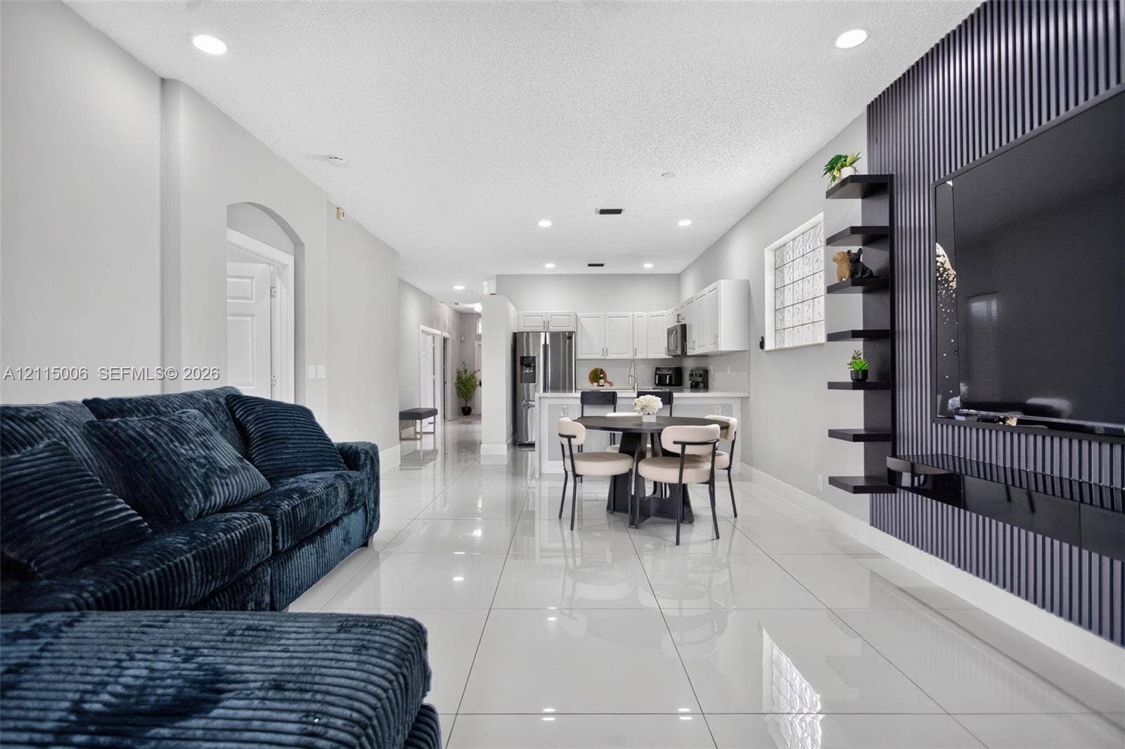 4812 NW 19th Street, Coconut Creek, FL 33063 Interior featuring polished tile flooring, recessed lighting, and a vertical slat accent wall with integrated shelving