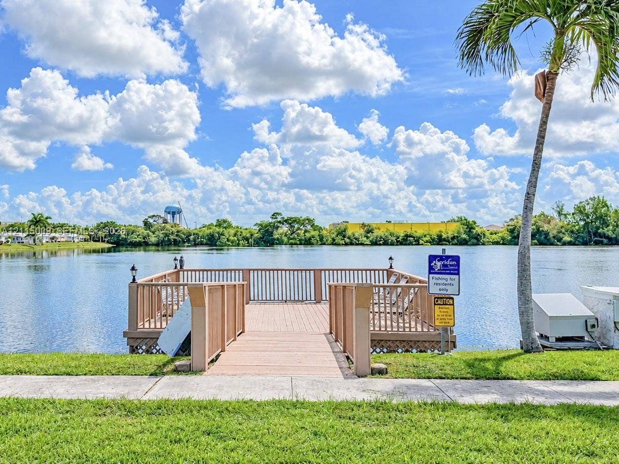 2300 Park Lane, #105, Hollywood, FL 33021 Waterfront wooden pier featuring perimeter railings and concrete sidewalk access