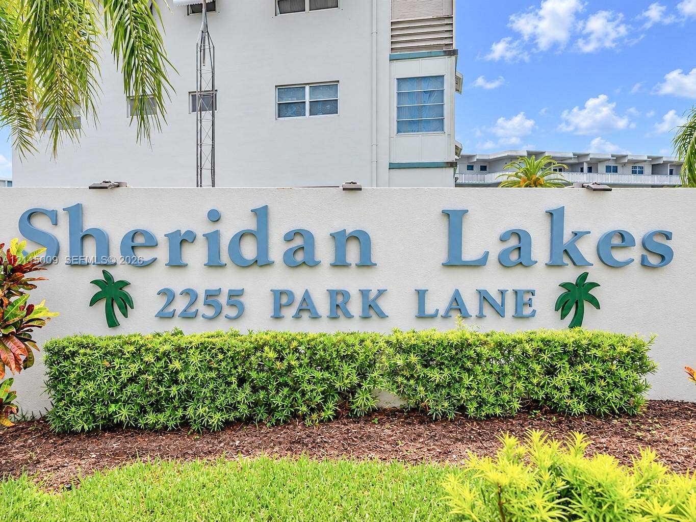 2300 Park Lane, #105, Hollywood, FL 33021 Monument signage featuring dimensional lettering and integrated landscape lighting, situated within a manicured garden bed with mature shrubbery and mulch ground cover
