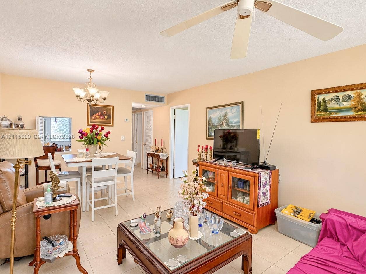 2300 Park Lane, #105, Hollywood, FL 33021 Open-concept interior featuring light-toned tile flooring, a multi-arm ceiling chandelier, and a white ceiling fan