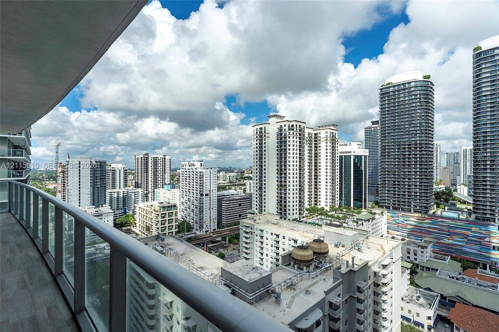 1100 S Miami Avenue, #2407, Miami, FL 33130 Private balcony with glass panel railing and tile flooring overlooking an expansive urban skyline