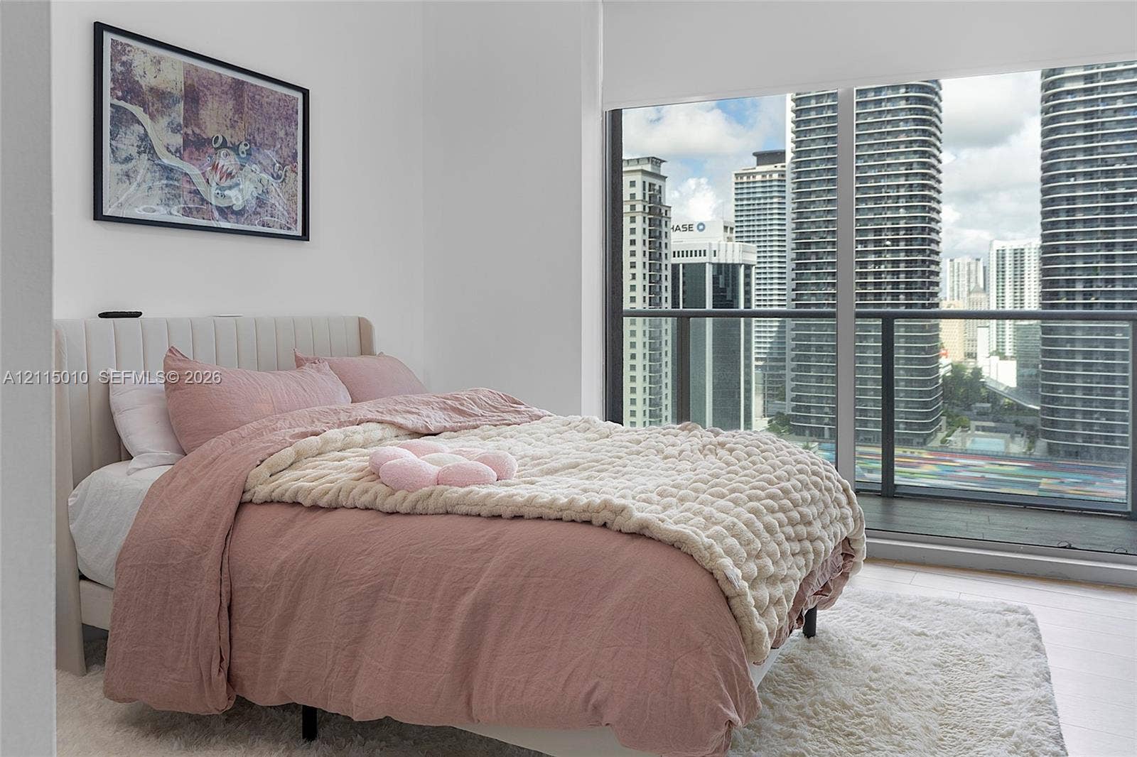 1100 S Miami Avenue, #2407, Miami, FL 33130 Floor-to-ceiling windows featuring urban skyline exposure, integrated balcony access with dark-framed railing, and light-toned hard-surface flooring
