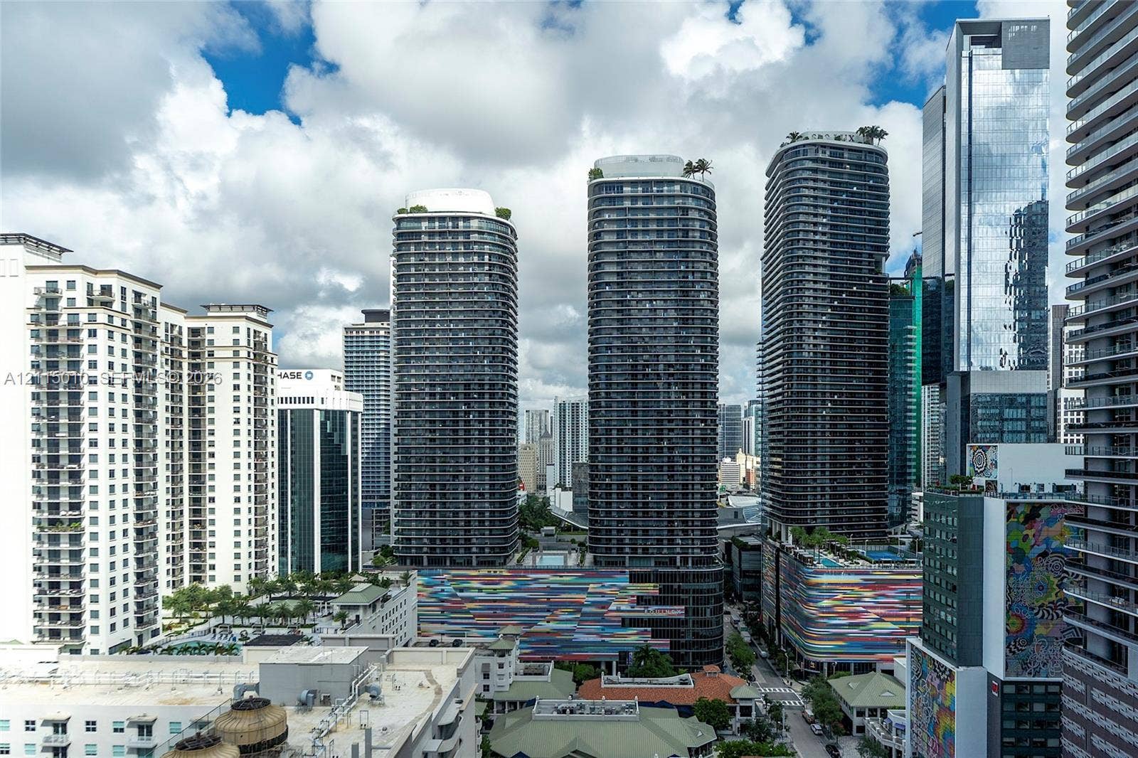 1100 S Miami Avenue, #2407, Miami, FL 33130 High-rise urban landscape featuring contemporary glass skyscrapers, private balconies, rooftop greenery, and colorful architectural facade accents