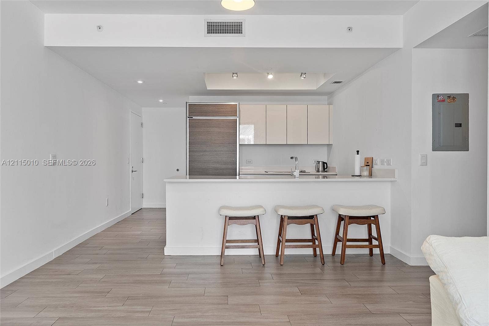 1100 S Miami Avenue, #2407, Miami, FL 33130 Kitchen featuring flat-panel cabinetry, wood-finish paneling on a built-in refrigerator, stone-surface countertop, recessed ceiling lighting, and wood-finish flooring