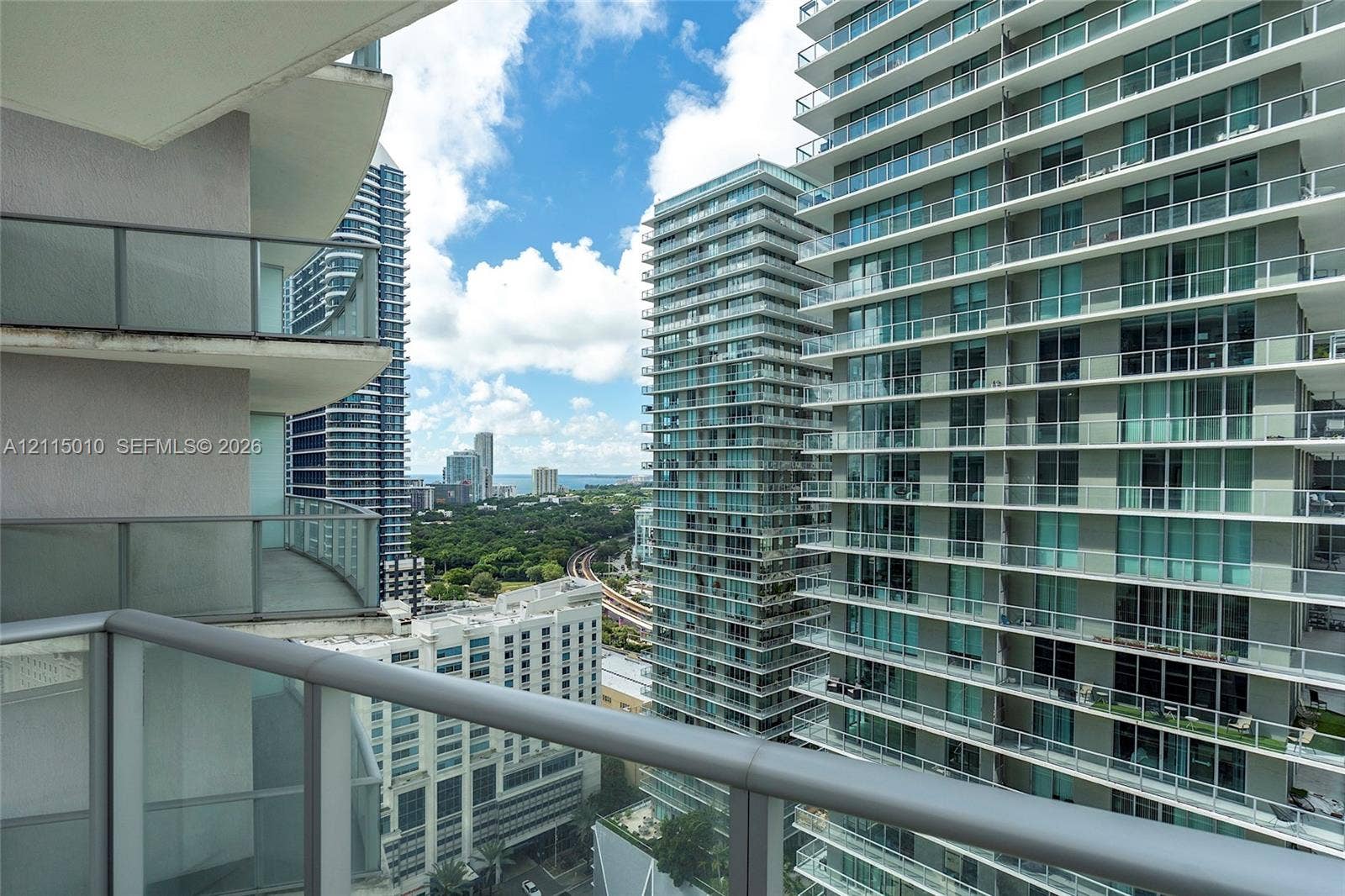 1100 S Miami Avenue, #2407, Miami, FL 33130 Private balcony featuring a glass-panel railing and metal handrail with an expansive urban skyline outlook