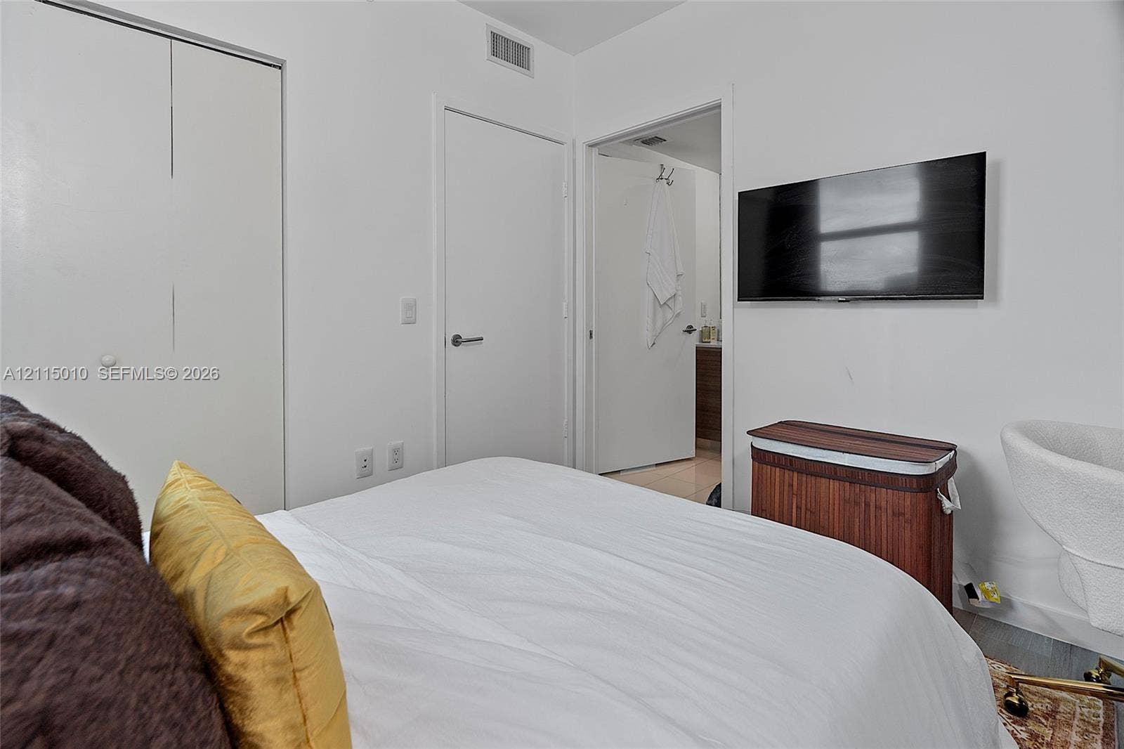 1100 S Miami Avenue, #2407, Miami, FL 33130 Neutral-toned room featuring a double-door reach-in closet and a wall-mounted flat-screen television