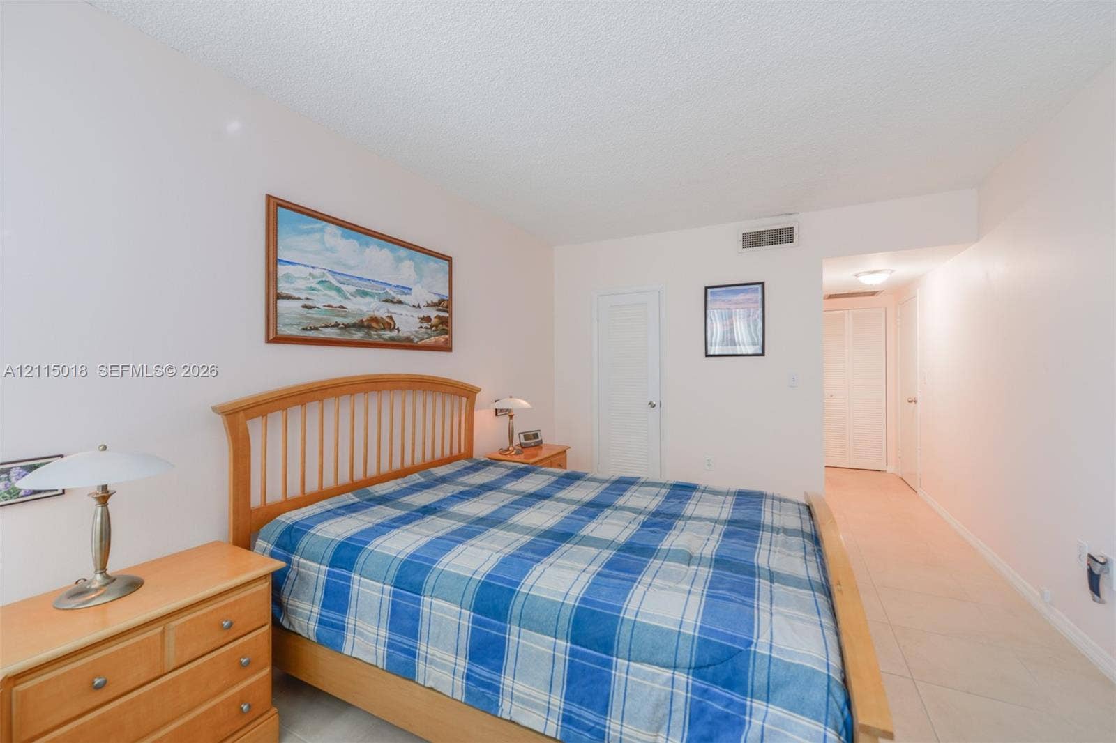 1950 S Ocean Drive, #20N, Hallandale Beach, FL 33009 Neutral-toned interior featuring smooth ceilings, ceramic tile flooring, and two white louvered closet doors