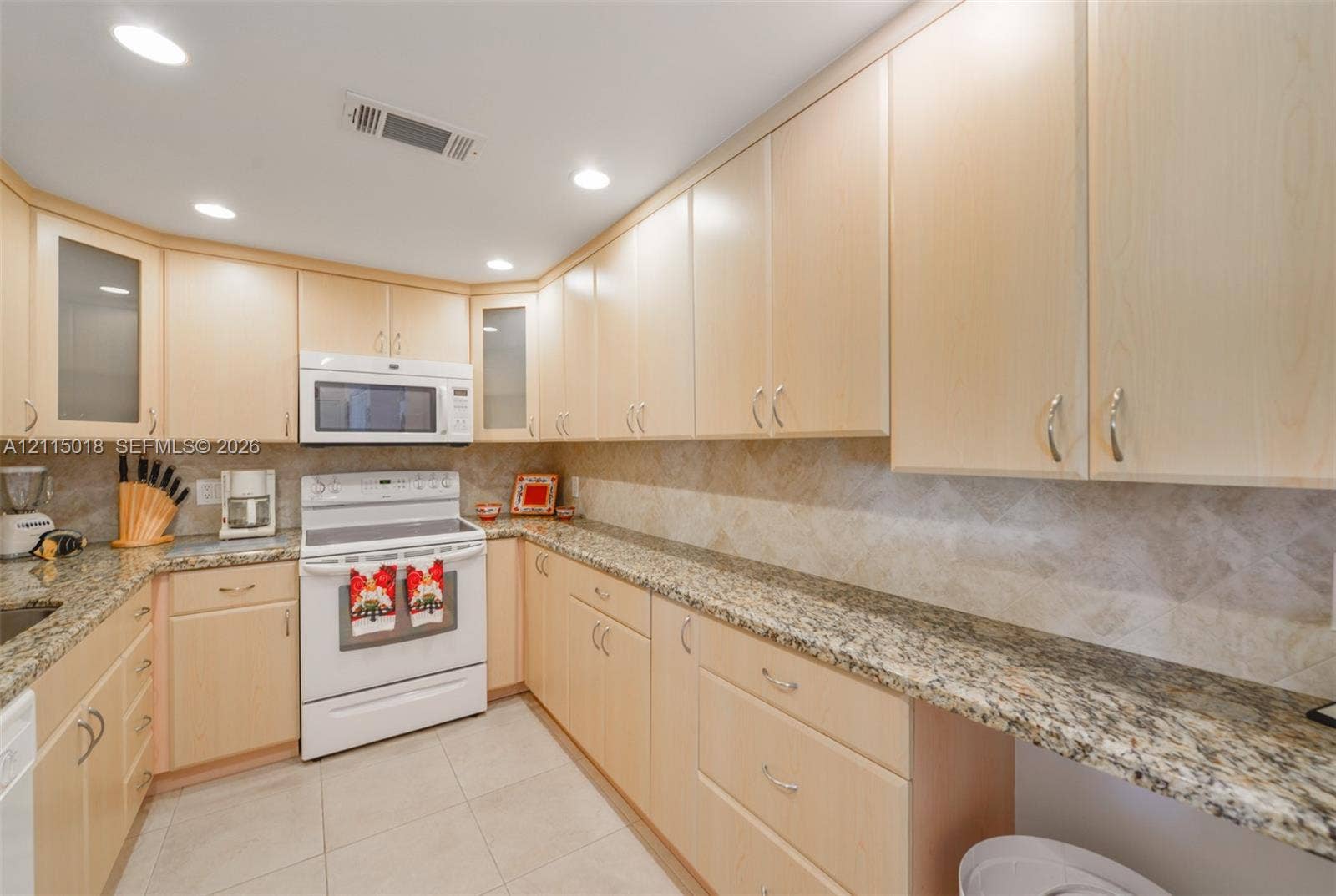 1950 S Ocean Drive, #20N, Hallandale Beach, FL 33009 Kitchen featuring light-tone wood cabinetry, stone countertops, tiled backsplash, recessed lighting, and a white freestanding range