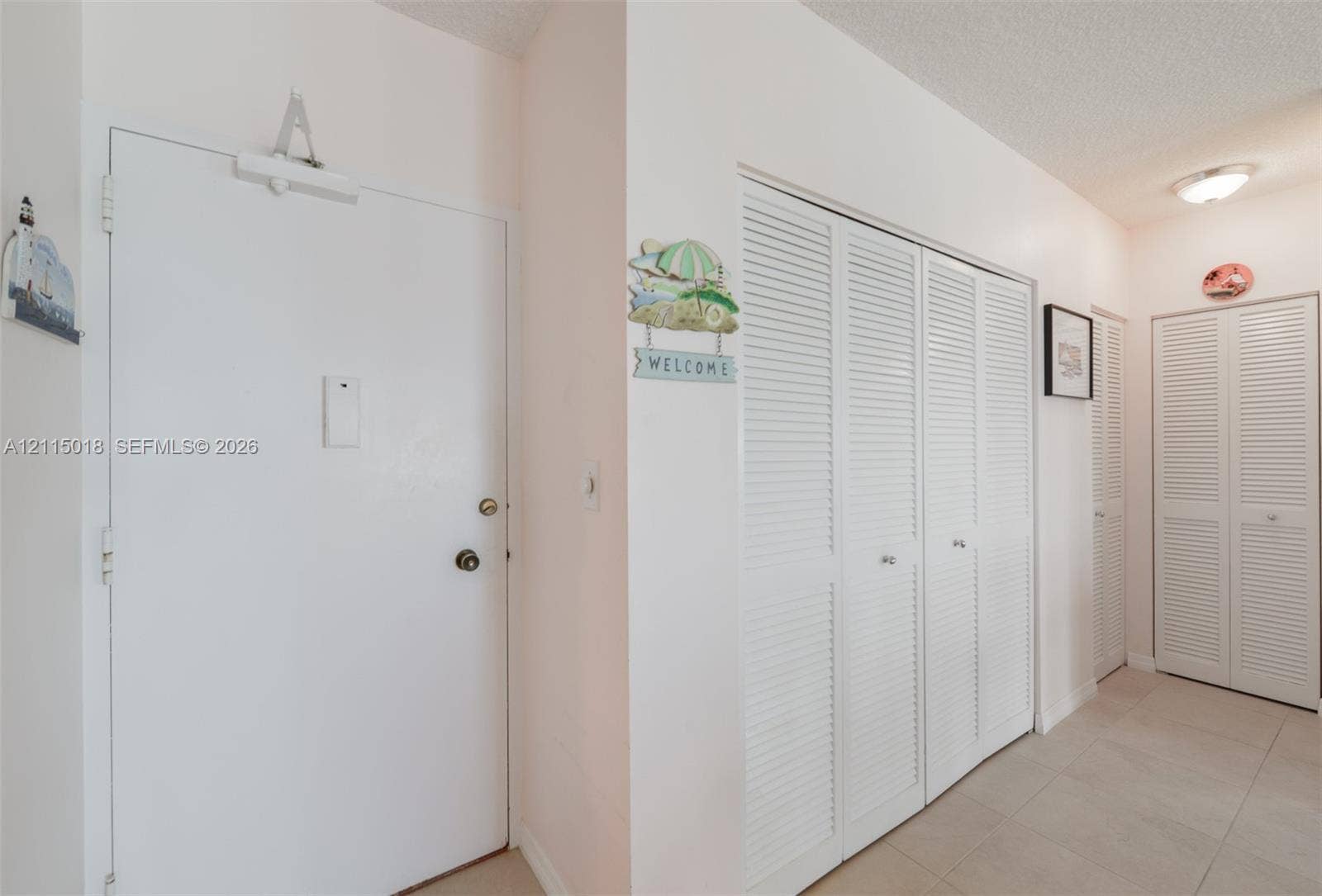 1950 S Ocean Drive, #20N, Hallandale Beach, FL 33009 Solid core entry door with overhead hydraulic closer, louvered bi-fold closet doors, and ceramic tile flooring