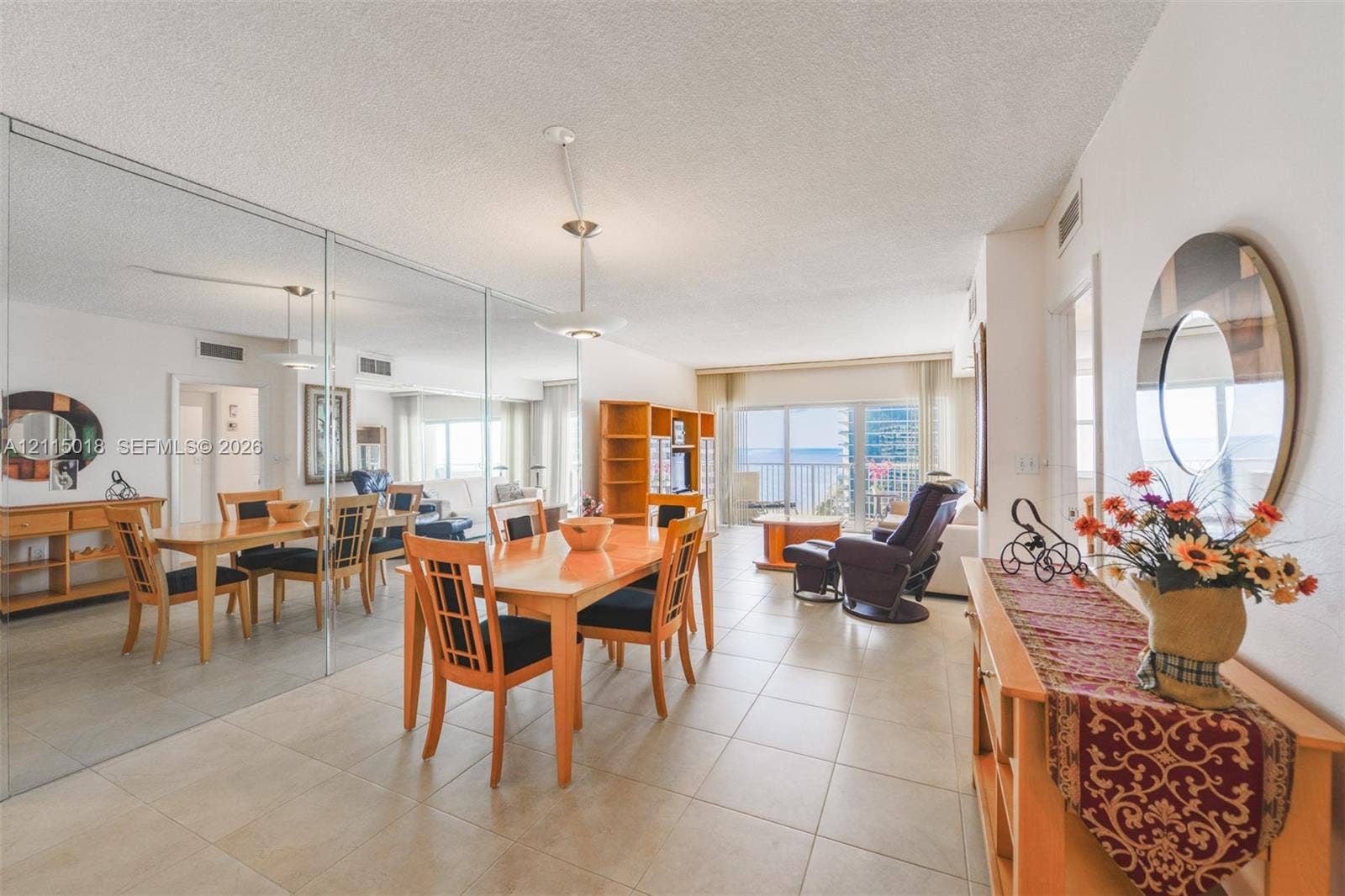 1950 S Ocean Drive, #20N, Hallandale Beach, FL 33009 Open-concept interior featuring large-format tile flooring, a floor-to-ceiling mirrored wall, recessed lighting, and a private balcony with glass sliding doors