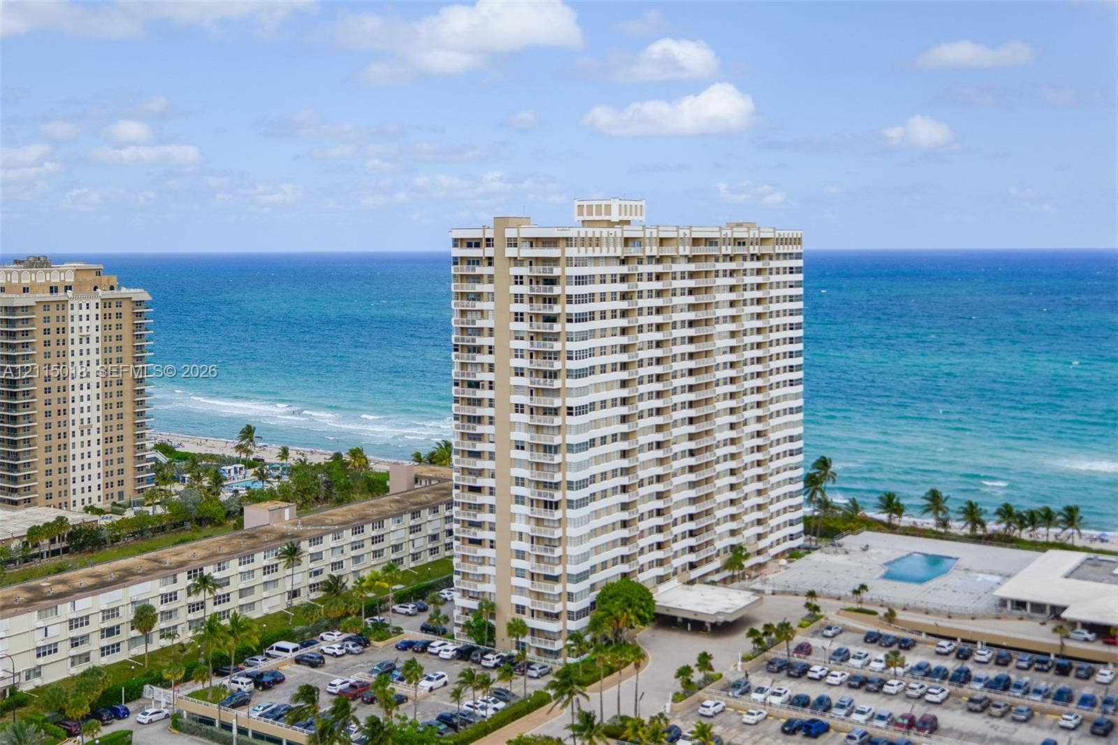 1950 S Ocean Drive, #20N, Hallandale Beach, FL 33009 High-rise building featuring private balconies, an outdoor swimming pool, and dedicated surface parking, positioned along the coastline