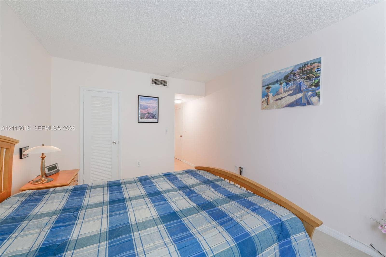 1950 S Ocean Drive, #20N, Hallandale Beach, FL 33009 Interior room featuring neutral wall paint, a white louvered closet door, and a textured ceiling