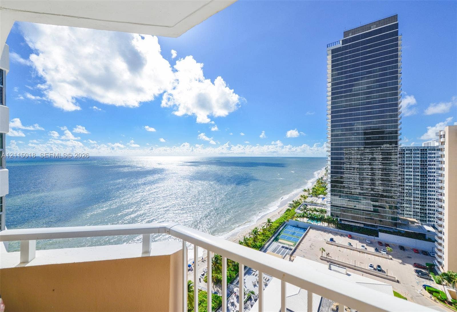 1950 S Ocean Drive, #20N, Hallandale Beach, FL 33009 Private balcony with white metal railings overlooking the ocean shoreline and high-rise cityscape