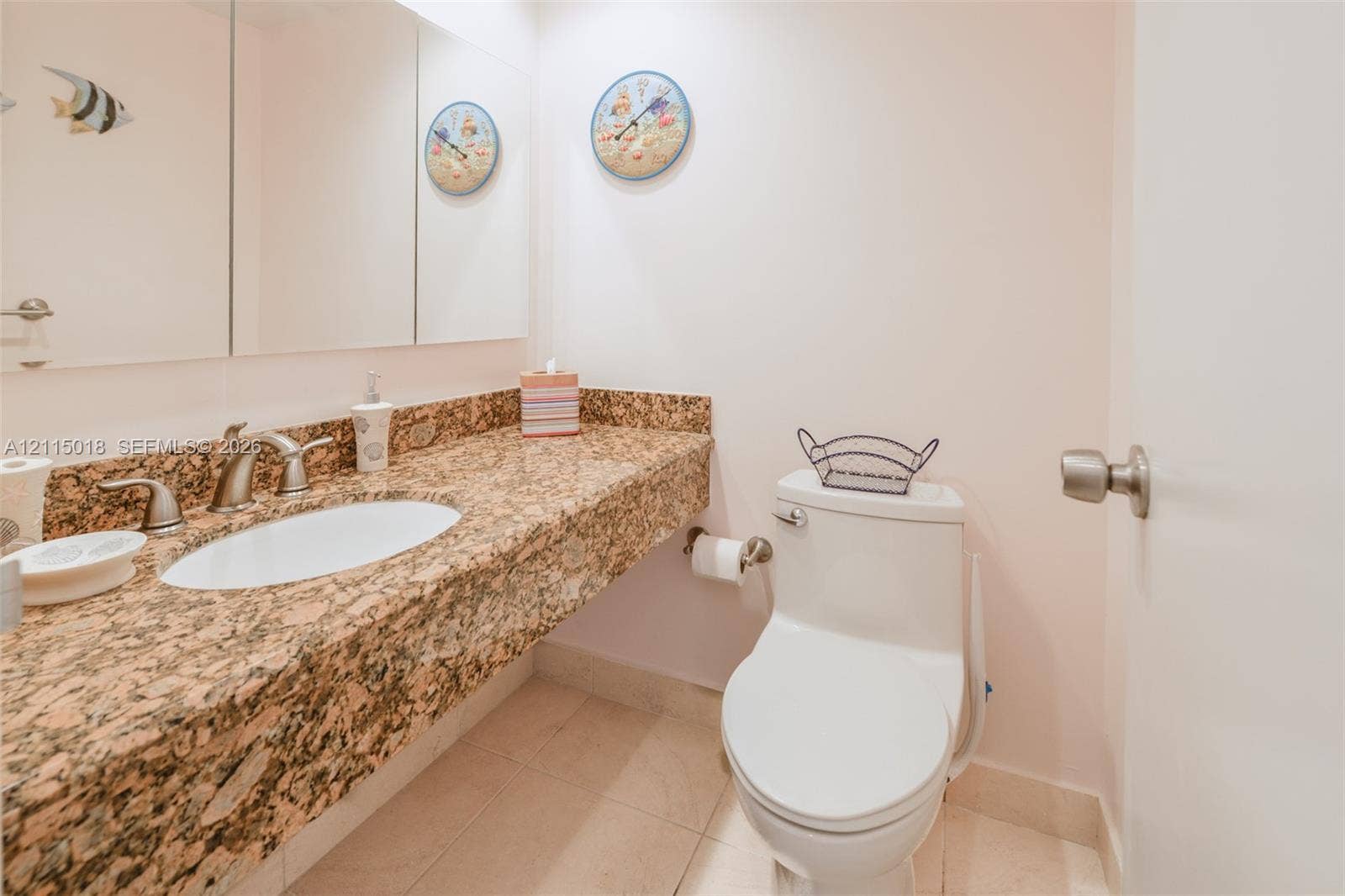 1950 S Ocean Drive, #20N, Hallandale Beach, FL 33009 Neutral stone countertop with an integrated oval sink, brushed nickel faucet, wall-spanning triple-panel mirror, and tile flooring