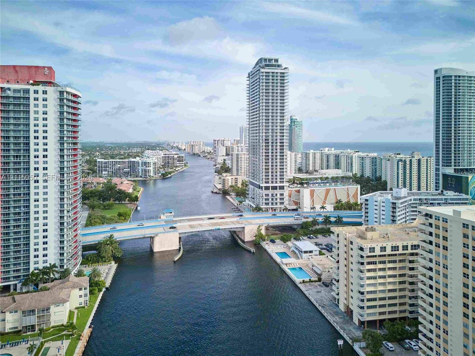 High-rise urban landscape featuring deep-water canal access, multiple multi-story residential towers, and a bridge infrastructure spanning the waterway
