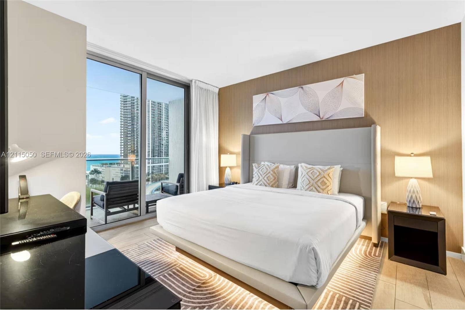 Floor-to-ceiling glass sliding doors, wood-finish wall paneling, light-tone wood-finish flooring, and balcony access