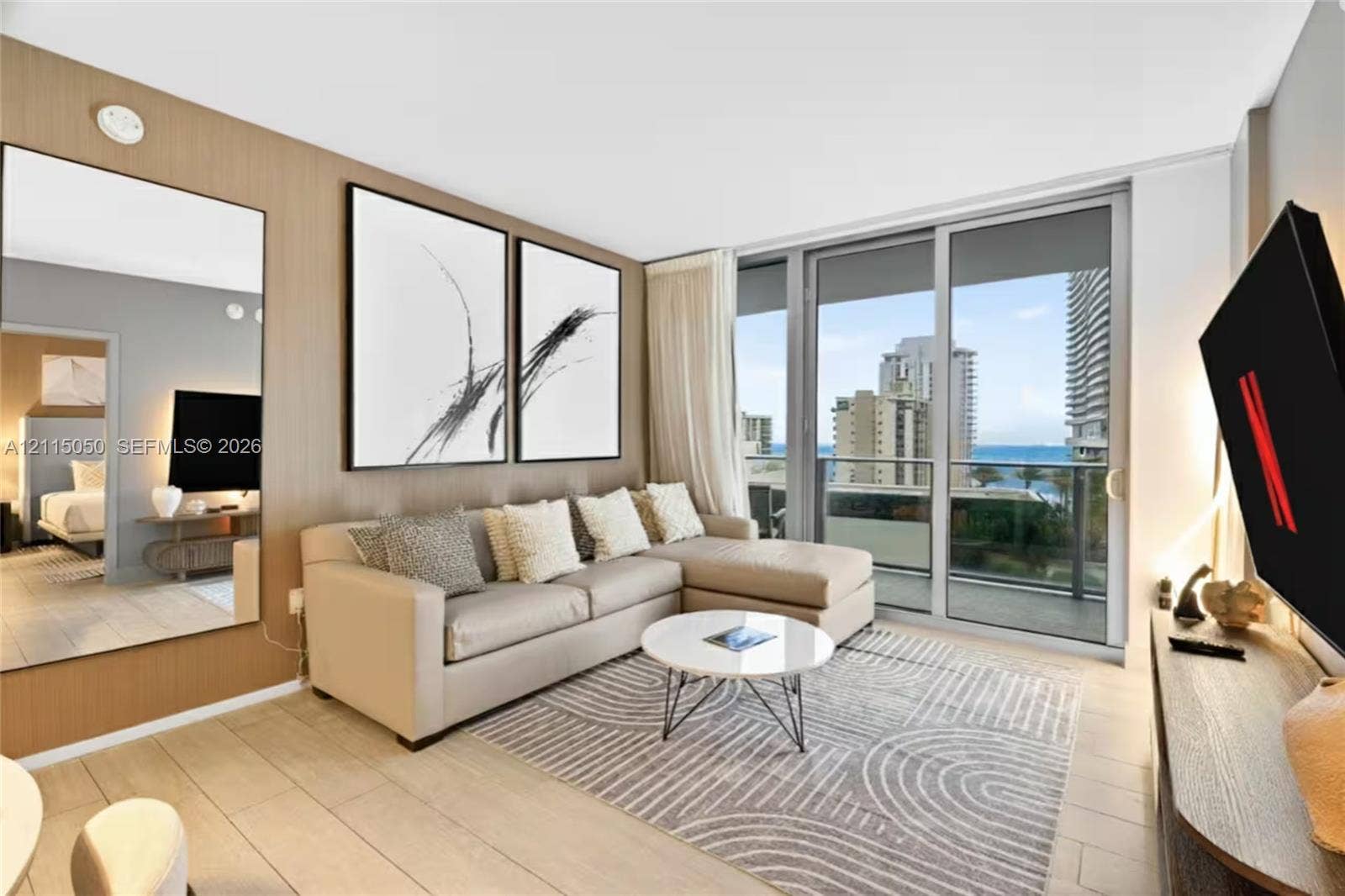 Wood-finish paneling, floor-to-ceiling glass sliding door, porcelain tile flooring, full-length wall mirror, and metal-framed balcony railing
