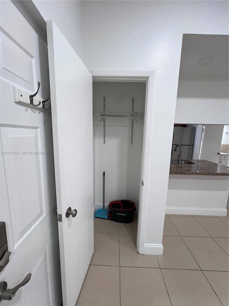17500 NW 67th Court, #H-19, Hialeah, Hialeah, FL 33015 Storage closet featuring built-in shelving, tile flooring, and a wall-mounted hook rack
