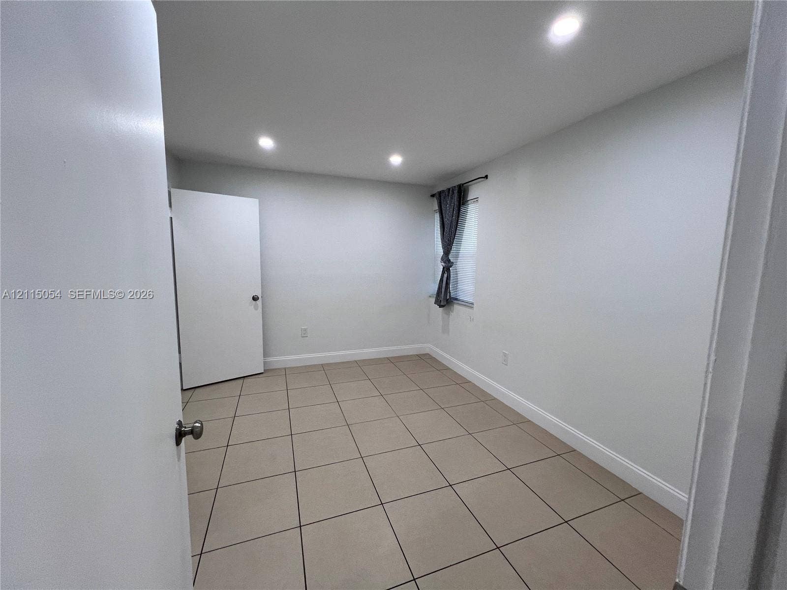 17500 NW 67th Court, #H-19, Hialeah, Hialeah, FL 33015 Interior room featuring large-format ceramic tile flooring, recessed ceiling lighting, and a single-panel interior door