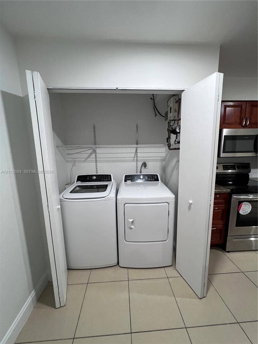 17500 NW 67th Court, #H-19, Hialeah, Hialeah, FL 33015 Laundry closet featuring bi-fold doors, white wire shelving, and tile flooring