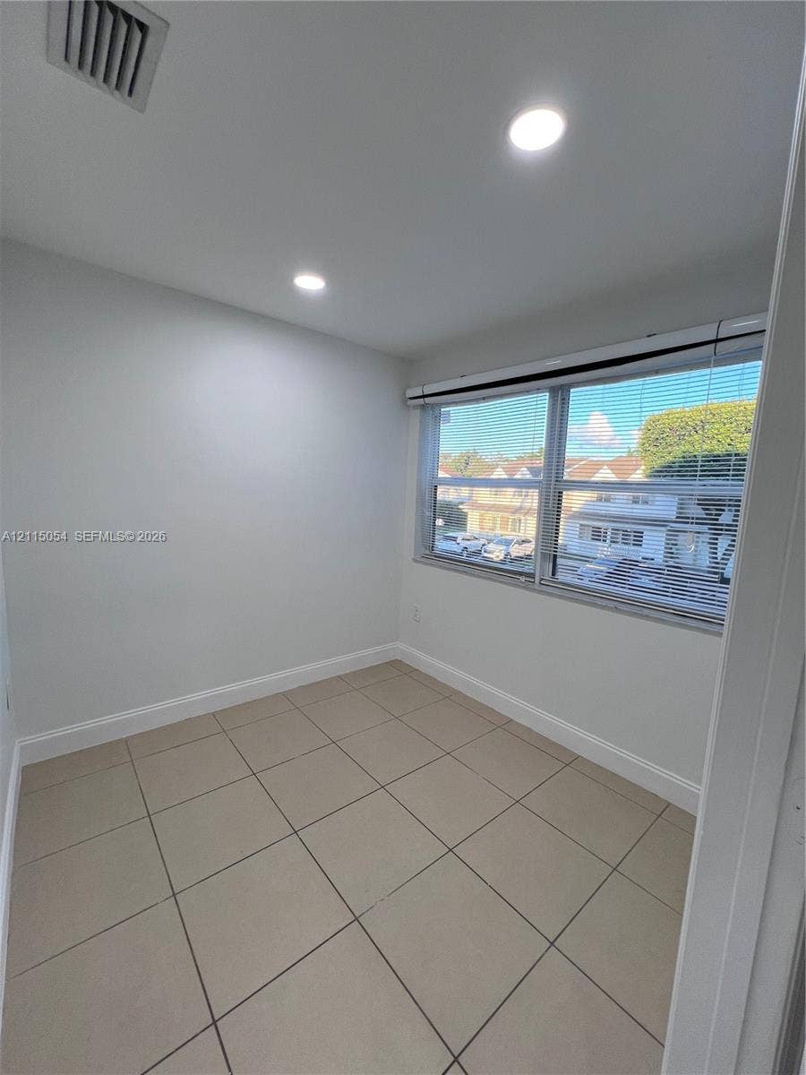 17500 NW 67th Court, #H-19, Hialeah, Hialeah, FL 33015 Interior room featuring large-format ceramic tile flooring, neutral wall tones, recessed lighting, and a double-pane horizontal sliding window