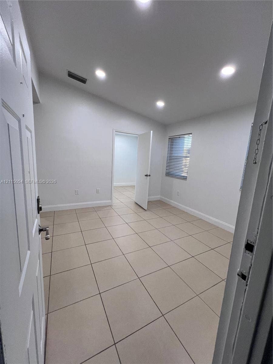 17500 NW 67th Court, #H-19, Hialeah, Hialeah, FL 33015 Interior room featuring large-format ceramic tile flooring, recessed ceiling lighting, and a window with horizontal blinds
