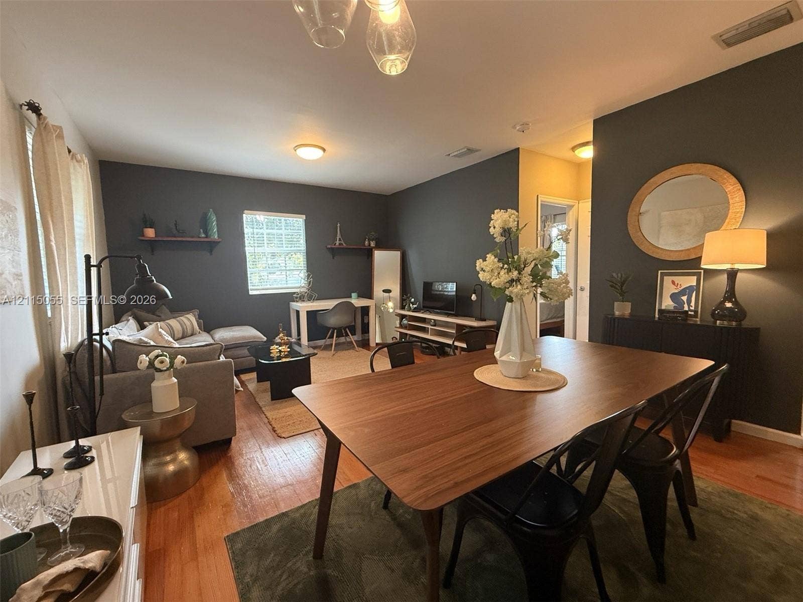 11728 NE 6th Avenue, #2, Biscayne Park, Biscayne Park, FL 33161 Open-concept room with wood-finish flooring, dark-toned accent walls, recessed lighting, and dual floating wall shelves