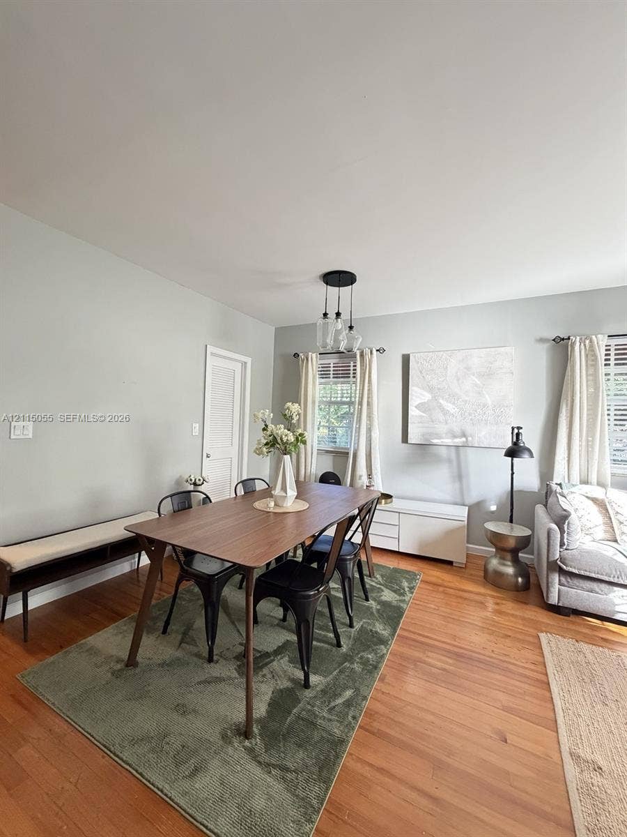 11728 NE 6th Avenue, #2, Biscayne Park, Biscayne Park, FL 33161 Wood-finish flooring, multi-pendant light fixture, and windows with horizontal blinds